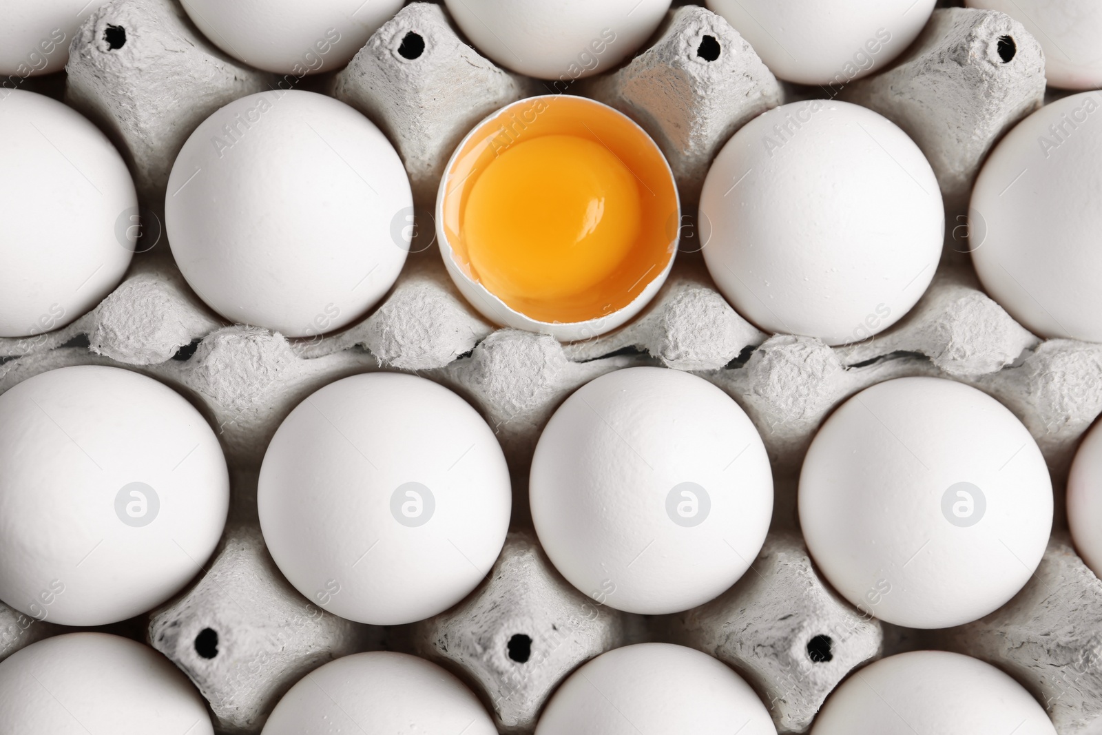 Photo of Many fresh raw chicken eggs in cartons as background, top view