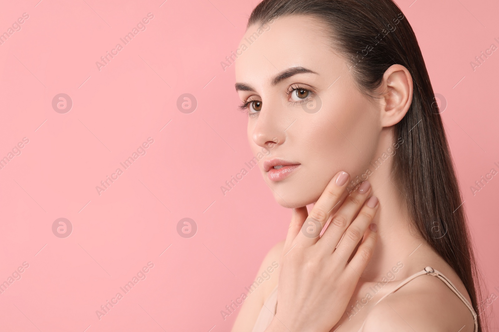 Photo of Portrait of beautiful young woman on pink background. Space for text