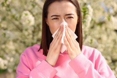 Photo of Woman with napkin suffering from seasonal allergy on spring day