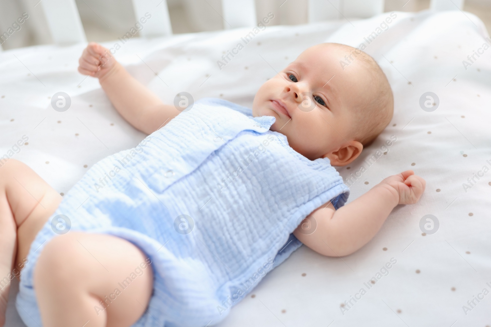 Photo of Cute little baby lying in crib at home