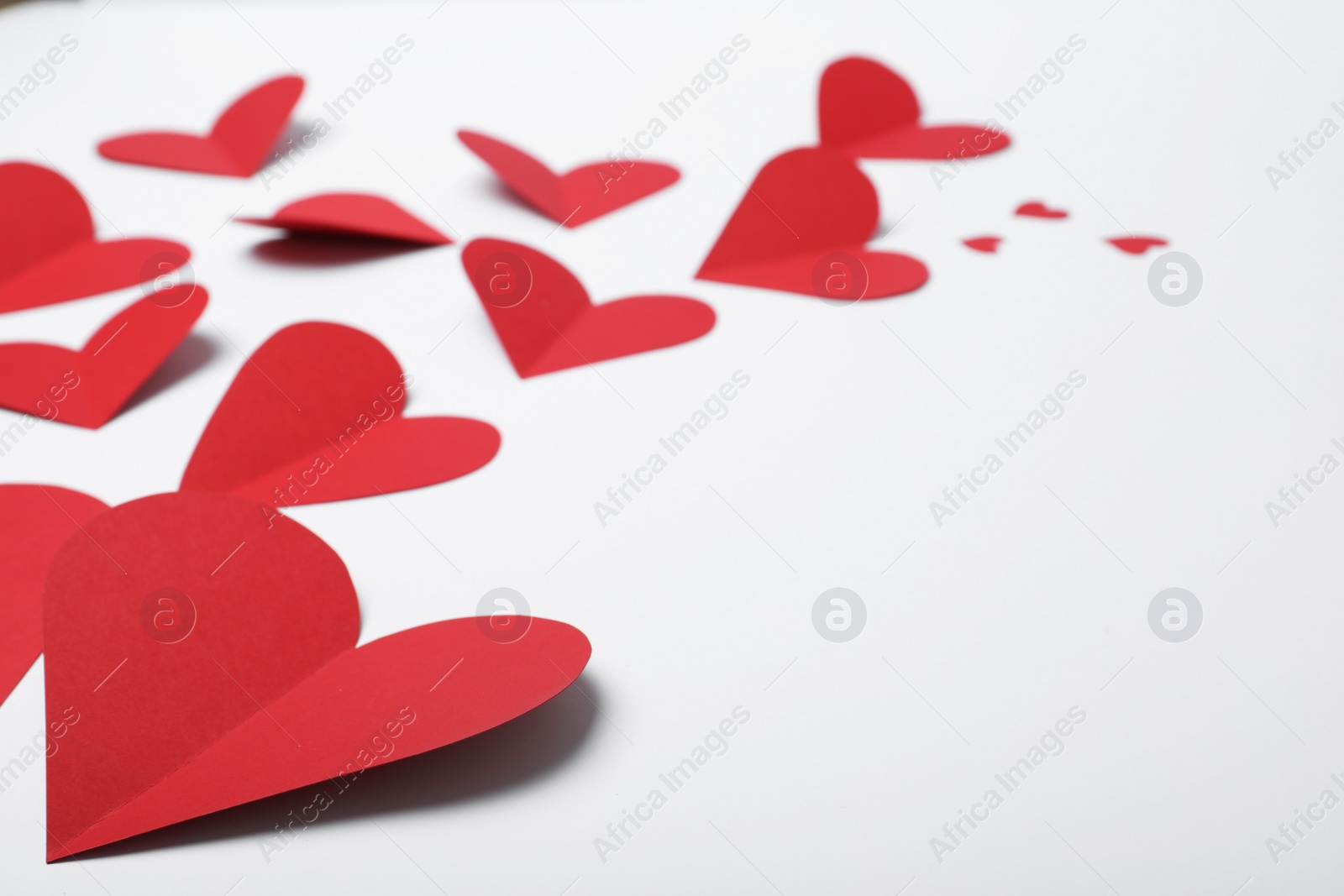 Photo of Many red paper hearts on white background