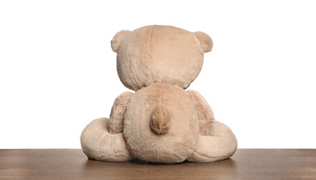 Photo of Cute teddy bear on wooden table against white background, back view
