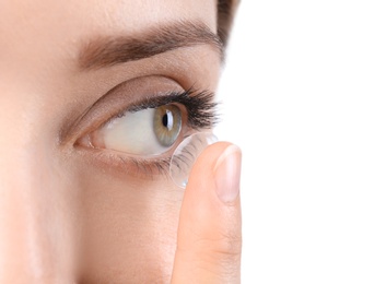 Photo of Young woman putting contact lens in her eye, closeup