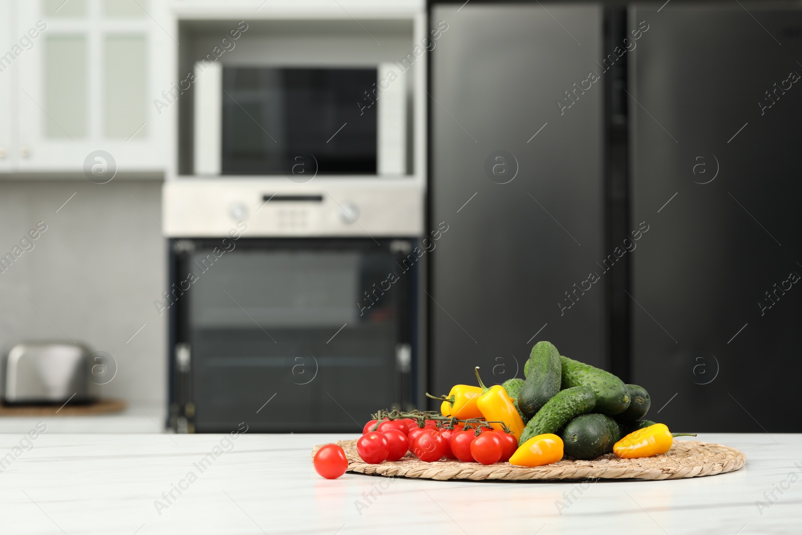 Photo of Fresh clean vegetables on white table in kitchen, space for text