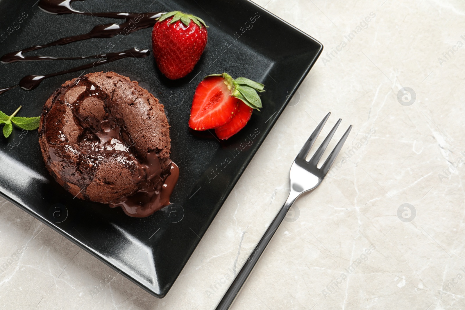 Photo of Plate of delicious fresh fondant with hot chocolate and strawberries on table, top view. Lava cake recipe