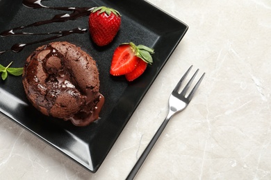 Plate of delicious fresh fondant with hot chocolate and strawberries on table, top view. Lava cake recipe