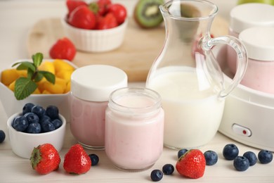Photo of Portion jars for yogurt maker and different fruits on white wooden table