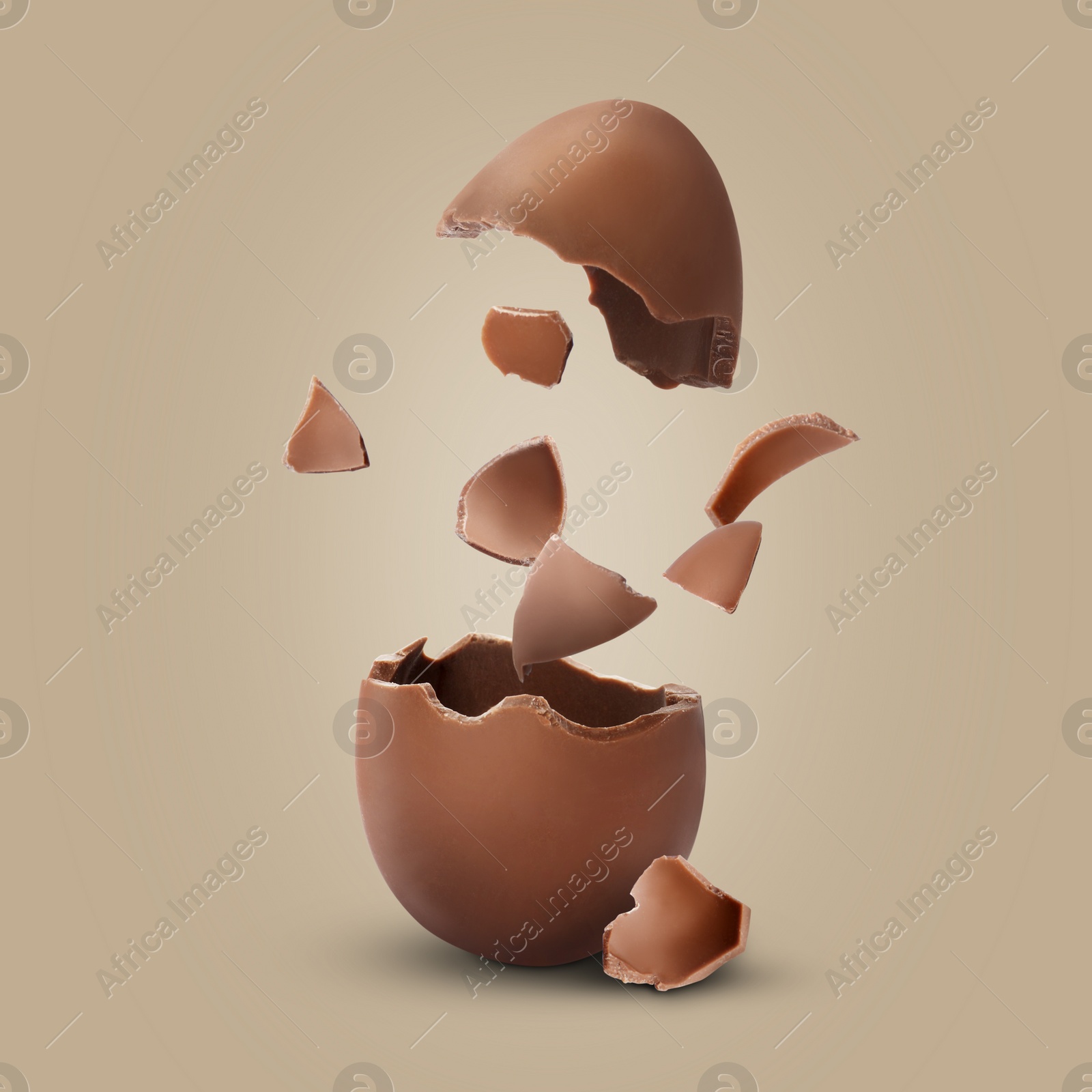 Image of Exploded milk chocolate egg on dark beige background