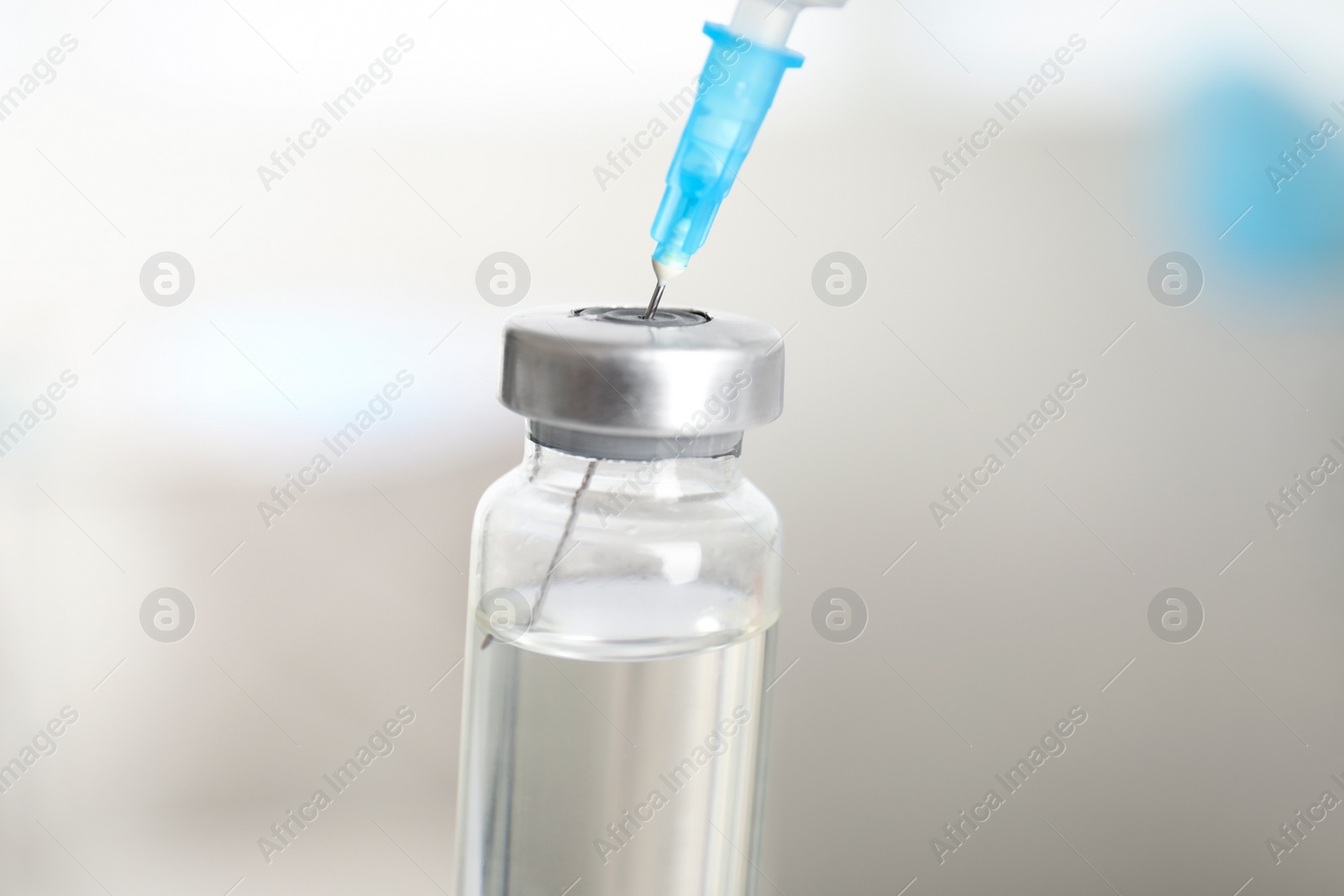 Photo of Vial and syringe on blurred background. Vaccination and immunization