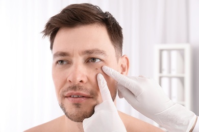 Doctor examining patient in clinic. Visiting dermatologist