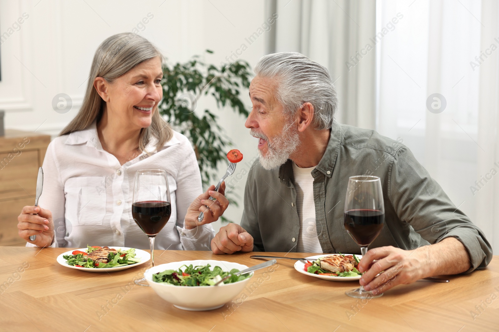 Photo of Happy senior couple having romantic dinner at home