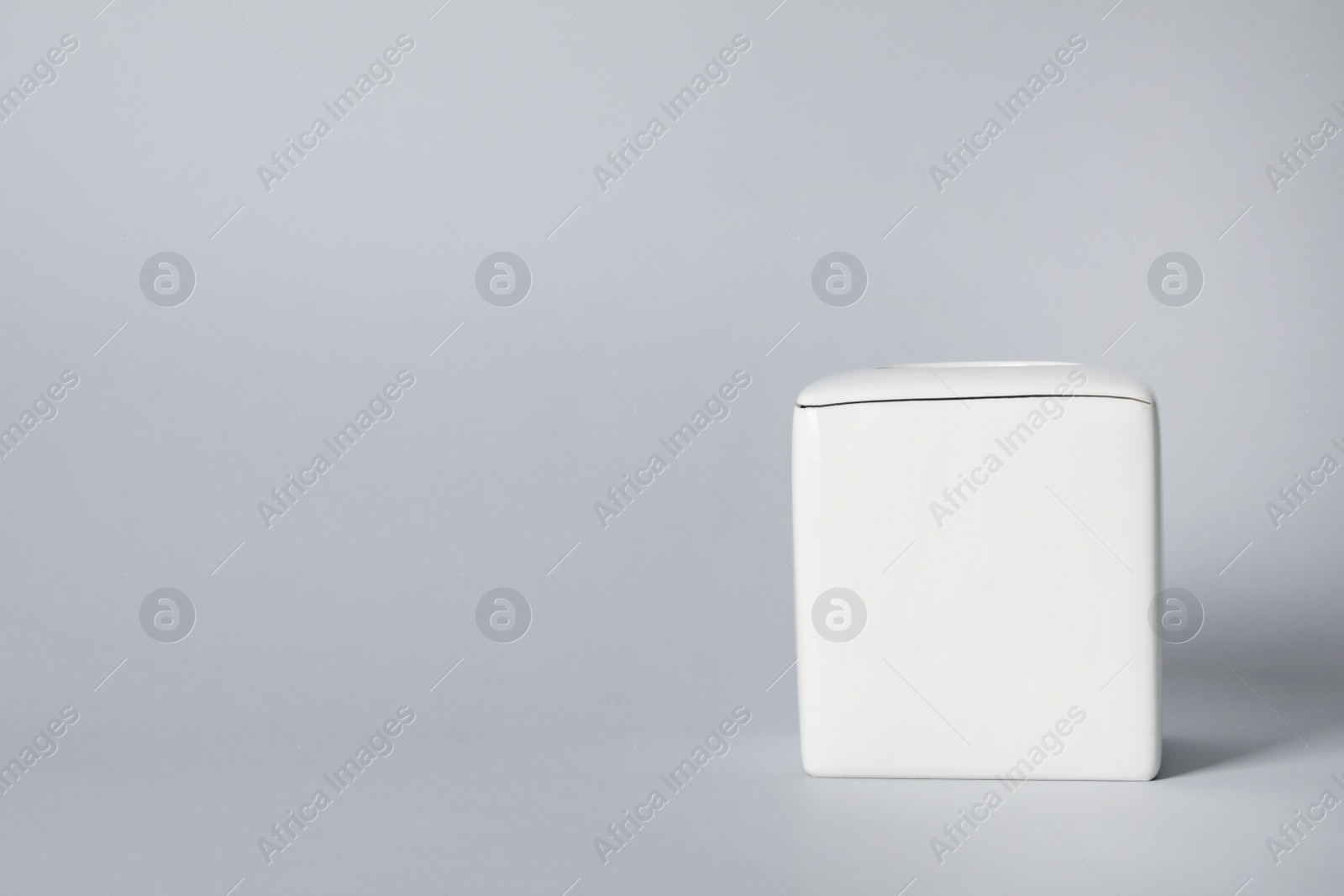 Photo of Empty napkin holder on gray background. Space for text