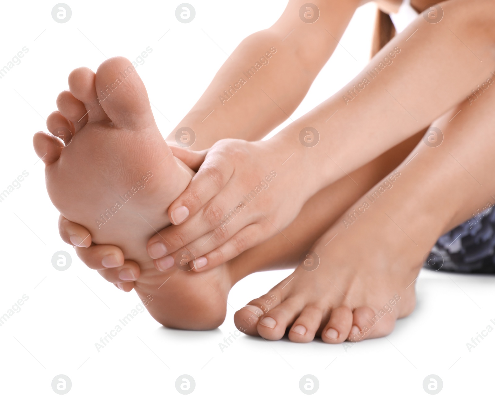 Photo of Young woman suffering from pain in foot on white background, closeup