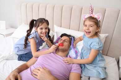 Photo of Cute little children painting facetheir father while he sleeping in bed at home