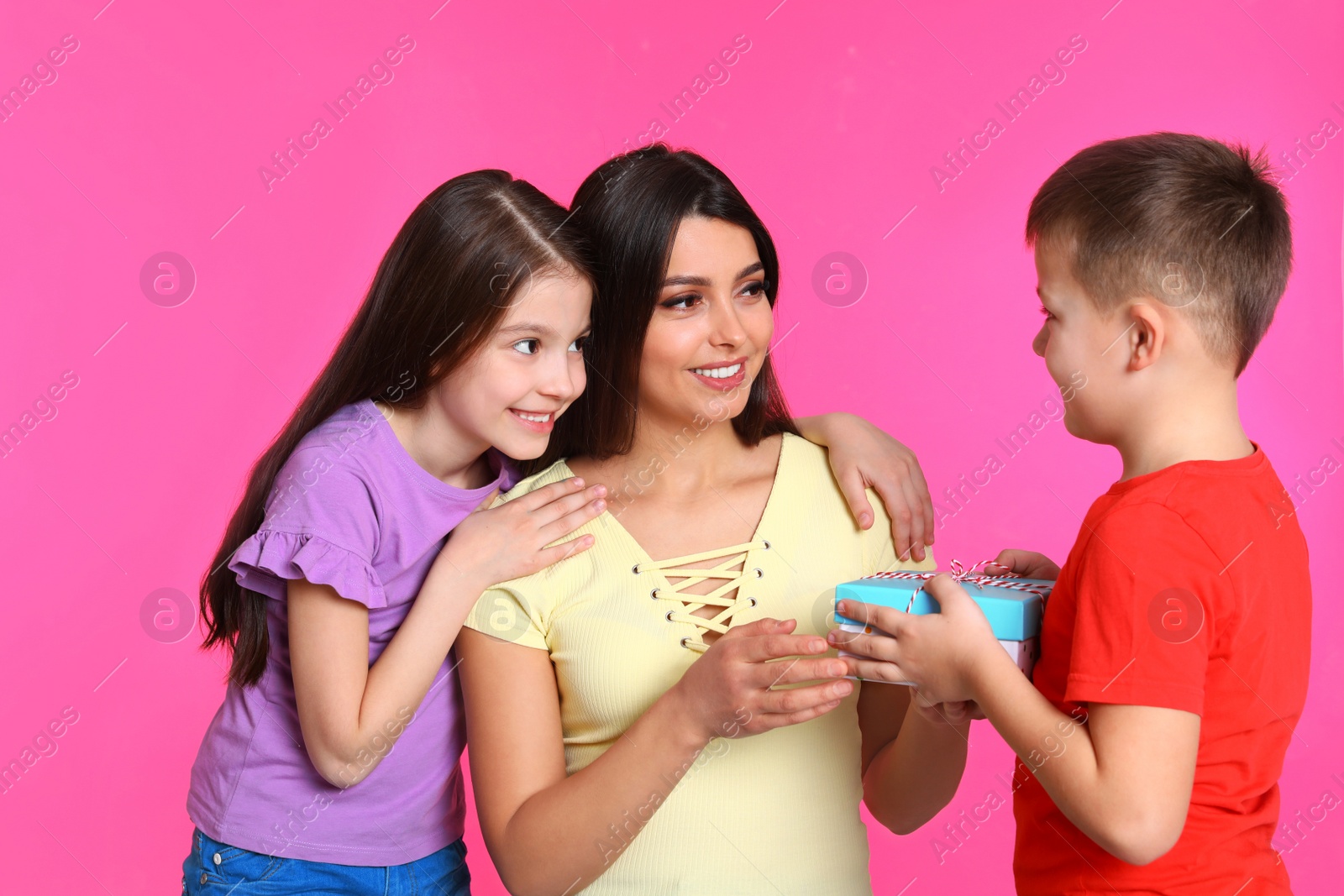 Photo of Son and daughter congratulating mom on color background. Happy Mother's Day