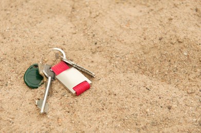 Keys on sand, space for text. Lost and found