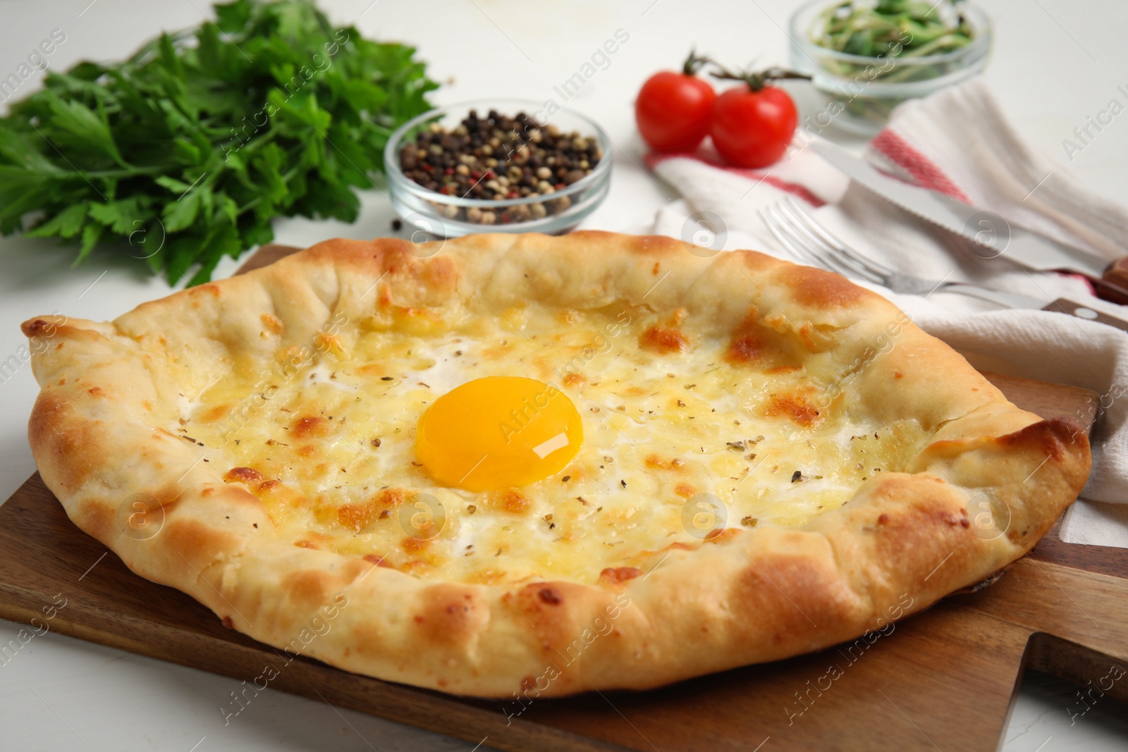 Photo of Fresh delicious Adjarian khachapuri on white table, closeup