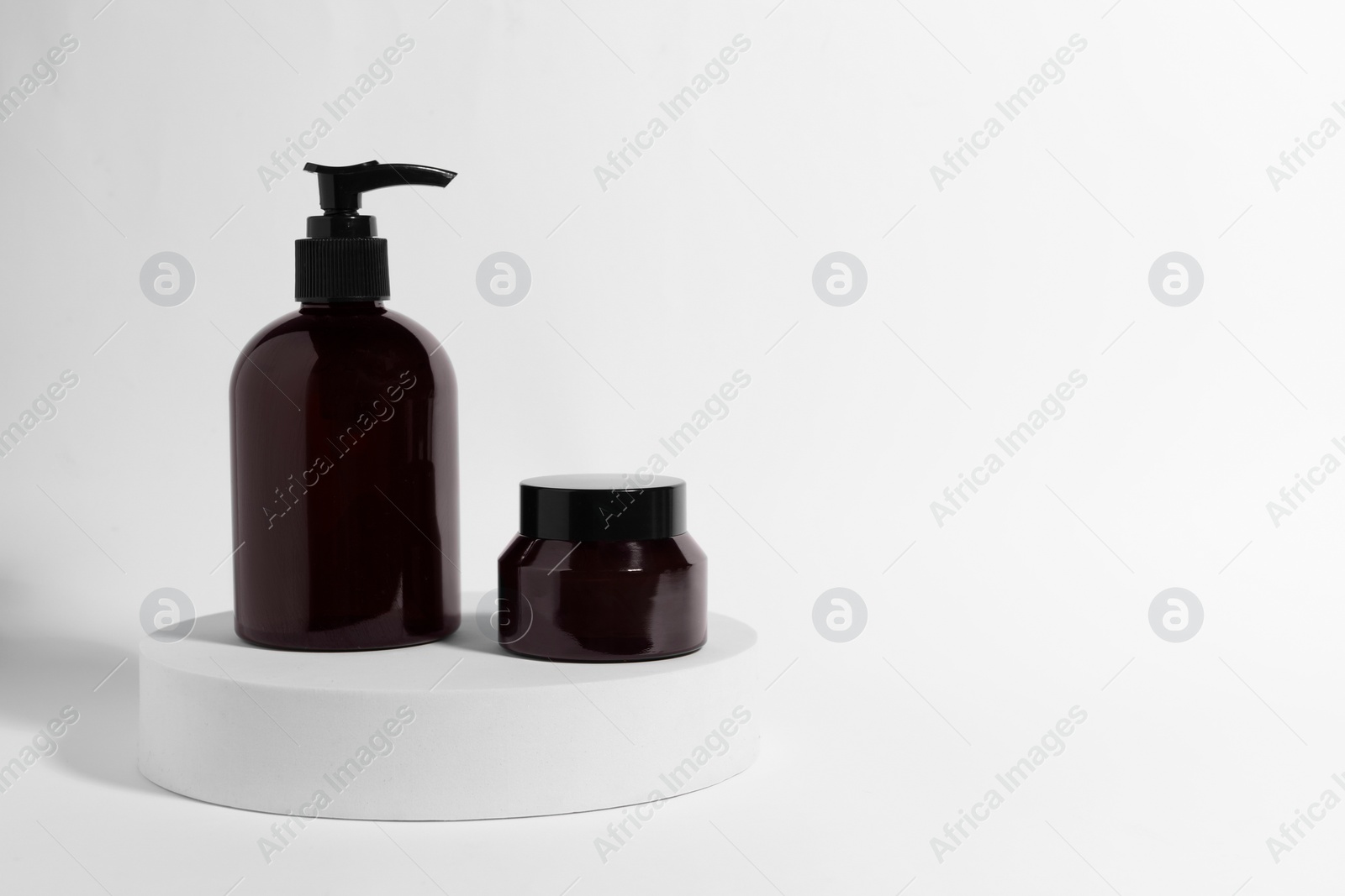 Photo of Bottle and jar with cosmetic products on white background, space for text