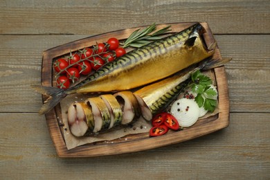 Delicious smoked mackerels and different products on wooden table, top view