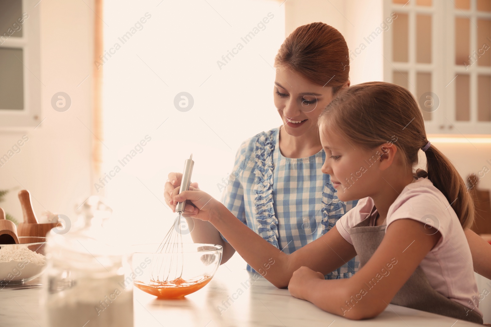 Photo of Mother and daughter making dough together in kitchen