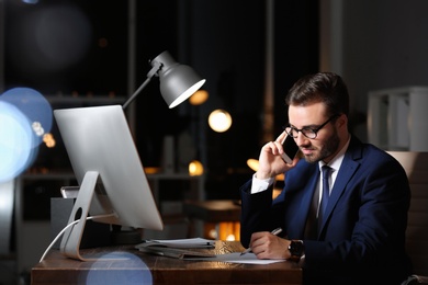 Young businessman working in office alone at night