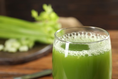 Glass of fresh celery juice against blurred background, closeup. Space for text