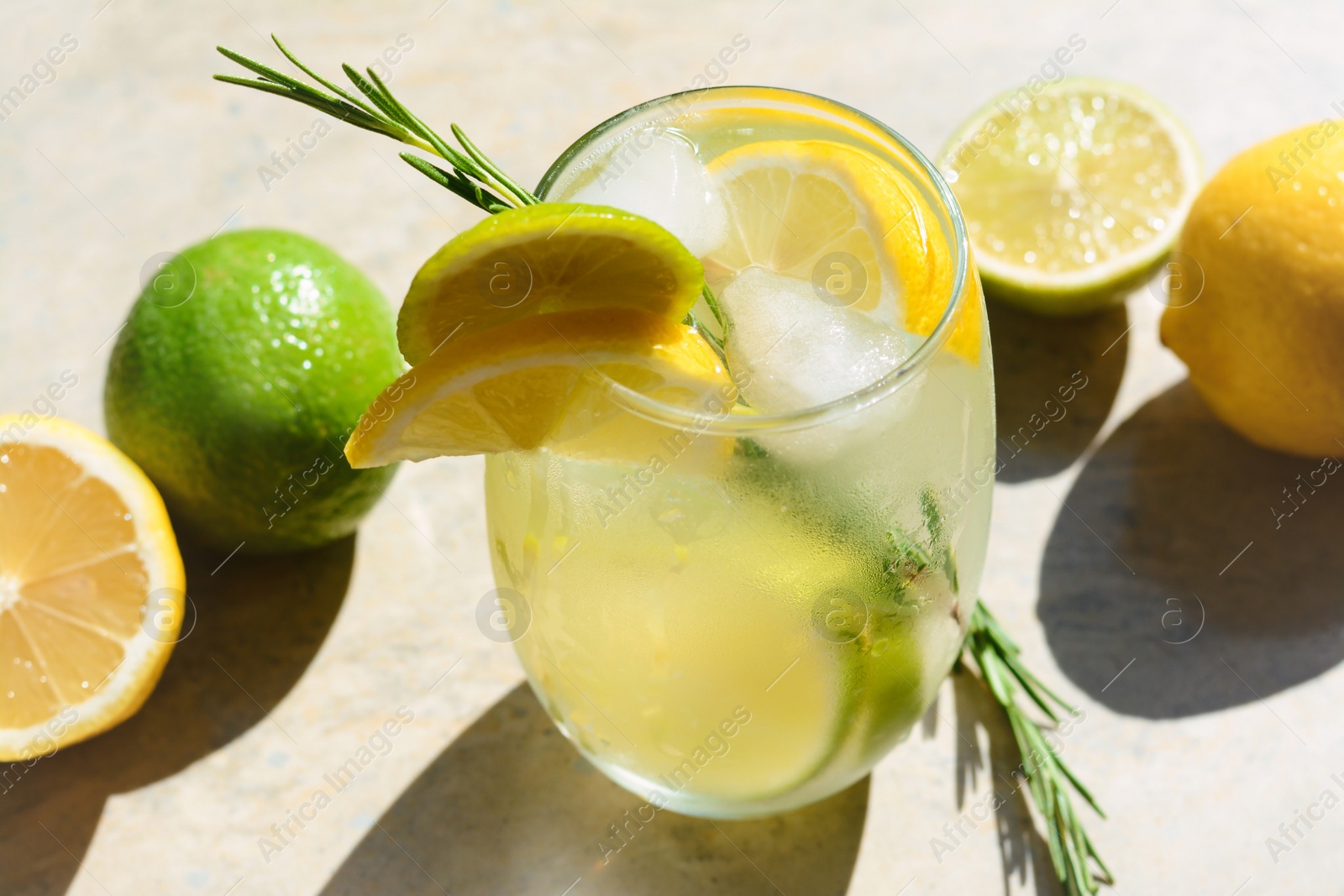 Photo of Tasty refreshing lemonade and ingredients on light table. Summer drink