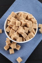 Photo of Brown sugar cubes on black table, flat lay