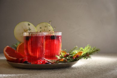 Aromatic Christmas Sangria in glasses served on light textured table, space for text