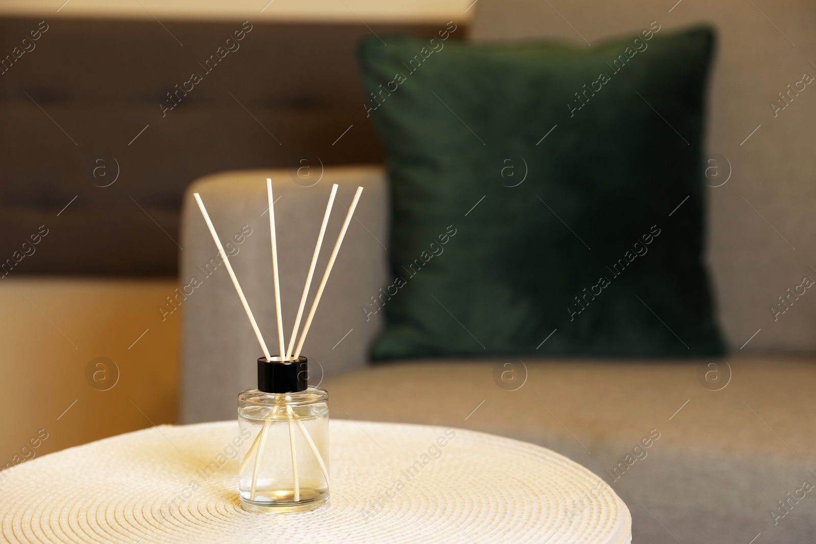 Photo of Aromatic reed air freshener on table indoors, space for text