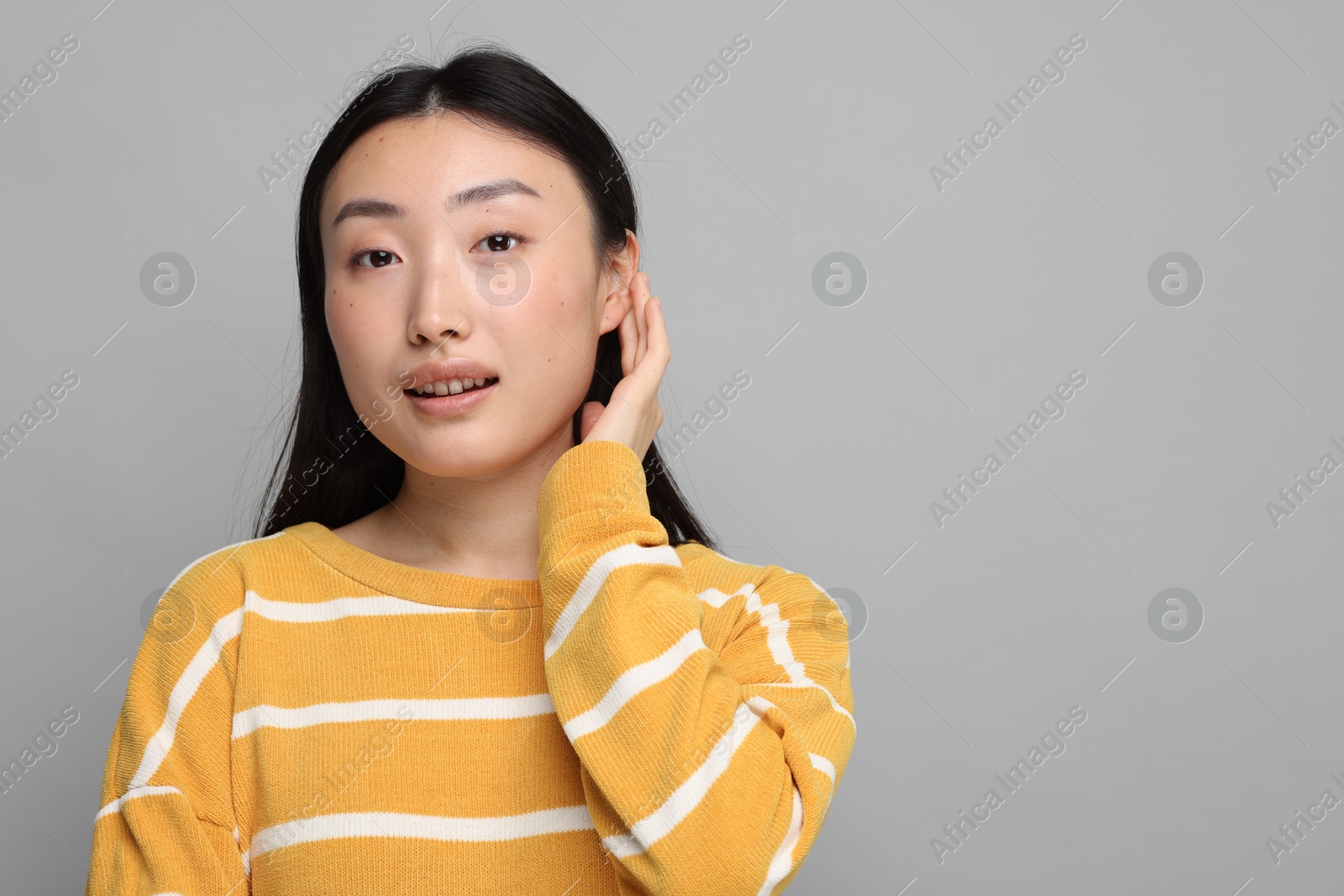 Photo of Portrait of smiling woman on grey background. Space for text