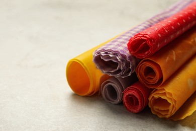 Photo of Colorful beeswax food wraps on light table, closeup. Space for text