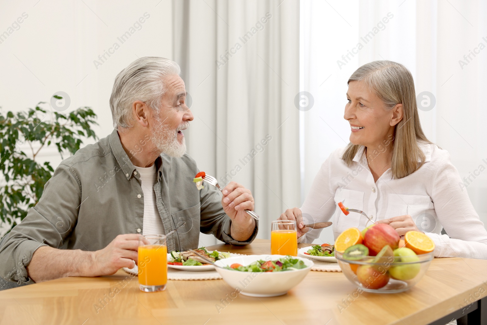 Photo of Happy senior couple having dinner at home