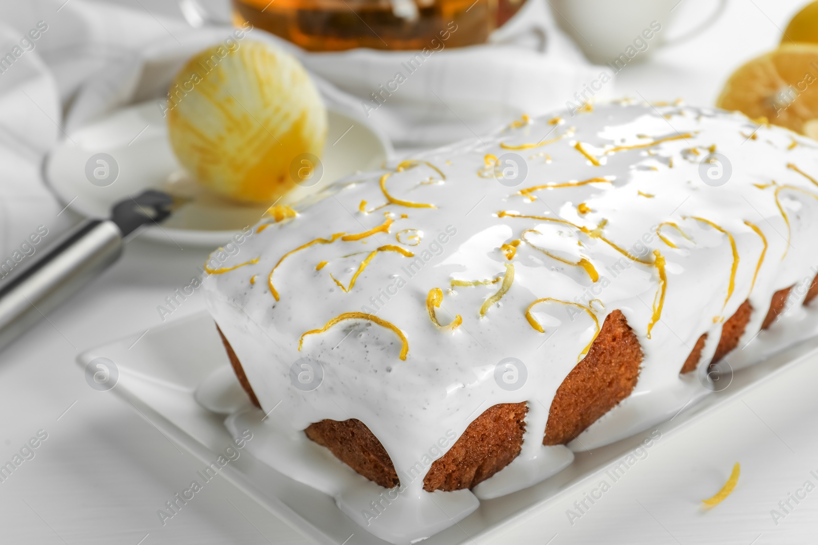 Photo of Tasty lemon cake with glaze on white table, closeup