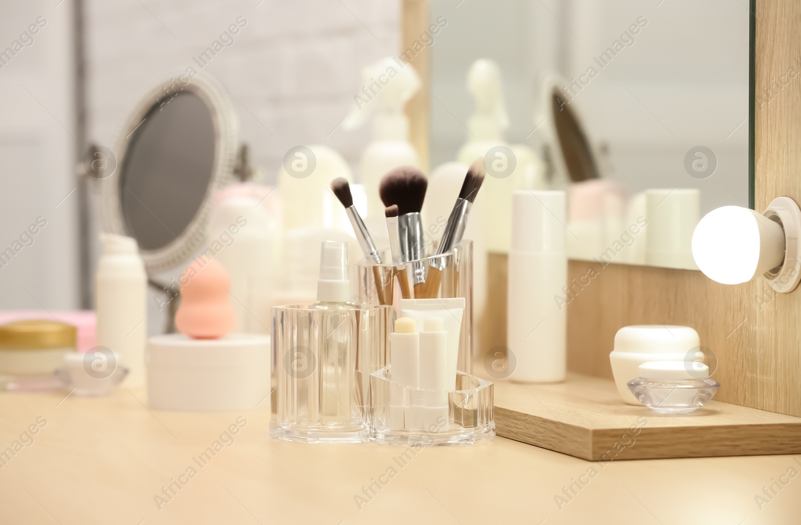 Photo of Organizer with cosmetic products and makeup accessories on dressing table indoors