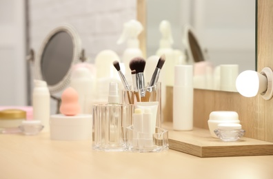 Organizer with cosmetic products and makeup accessories on dressing table indoors