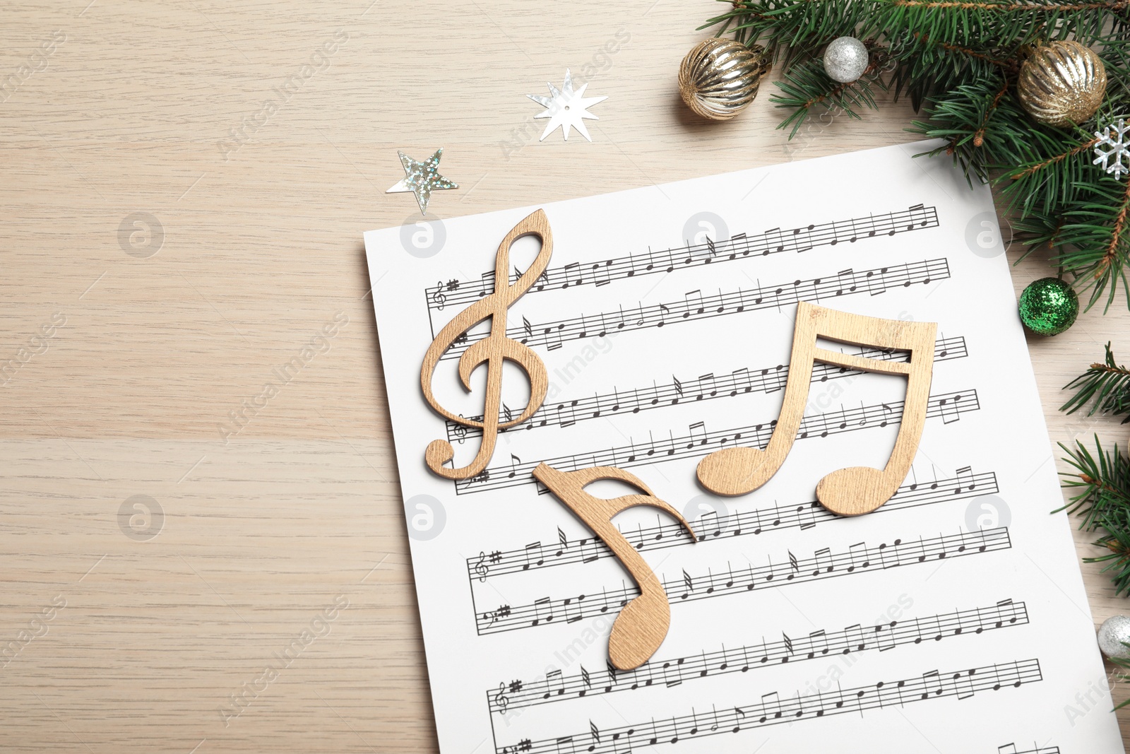 Photo of Composition with Christmas music sheets on wooden background, above view