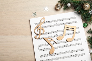 Composition with Christmas music sheets on wooden background, above view