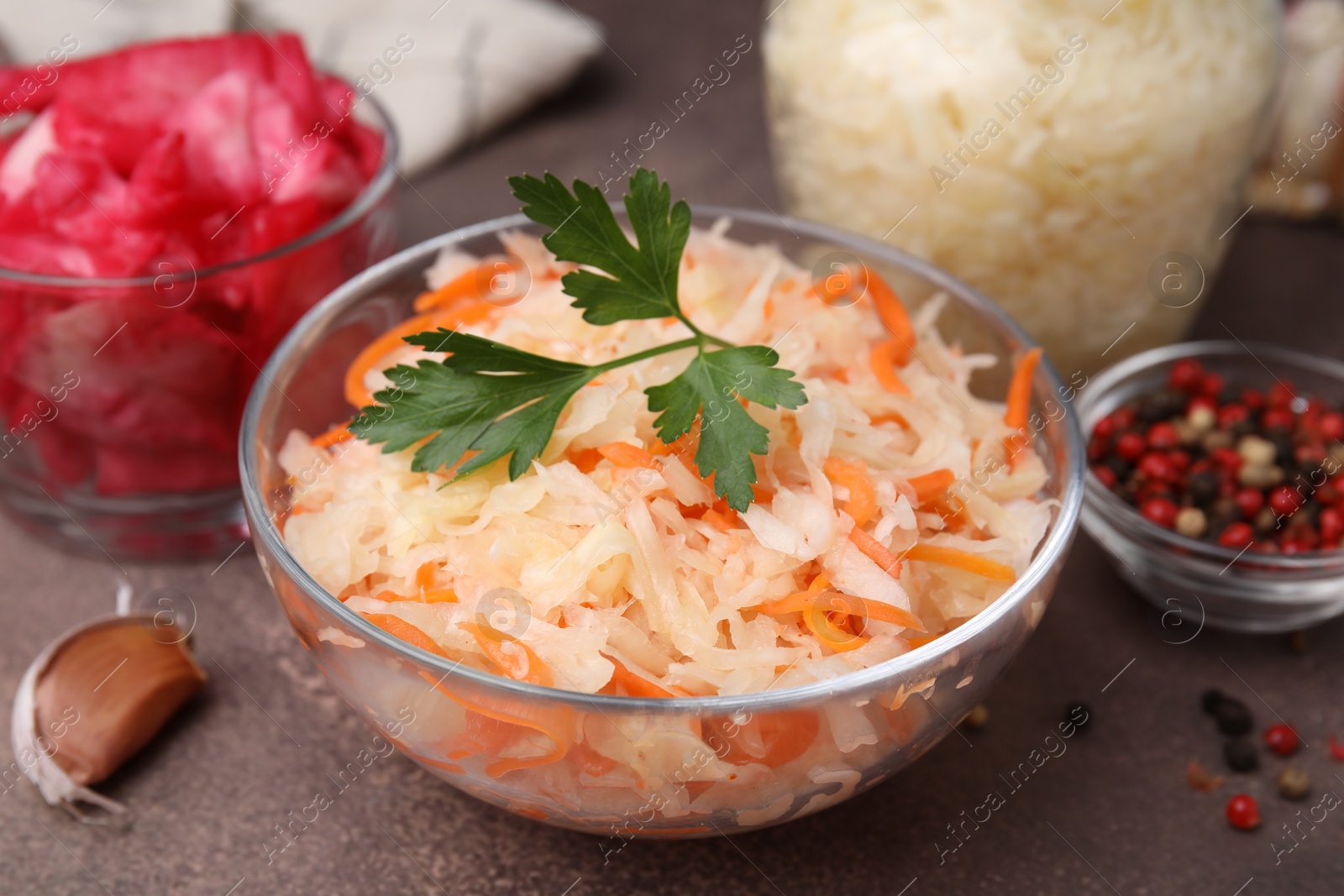 Photo of Delicious sauerkraut prepared according to different recipes on brown table, closeup view