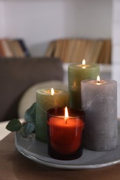 Beautiful burning candles on wooden table indoors, space for text
