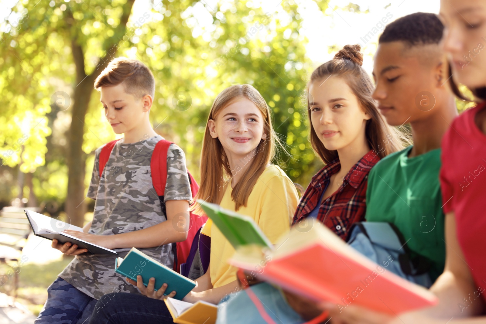 Photo of Group of children with books outdoors. Summer camp