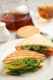 Photo of Delicious sandwiches with vegetables and cheese on plate, closeup