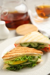 Delicious sandwiches with vegetables and cheese on plate, closeup