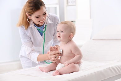 Photo of Children's doctor examining baby with stethoscope in hospital