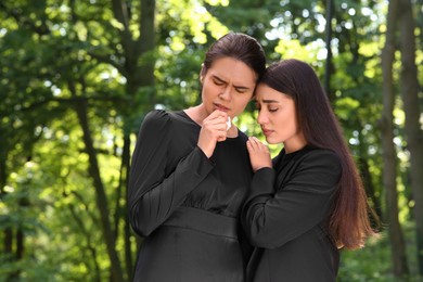 Photo of Sad women in black clothes mourning outdoors. Funeral ceremony