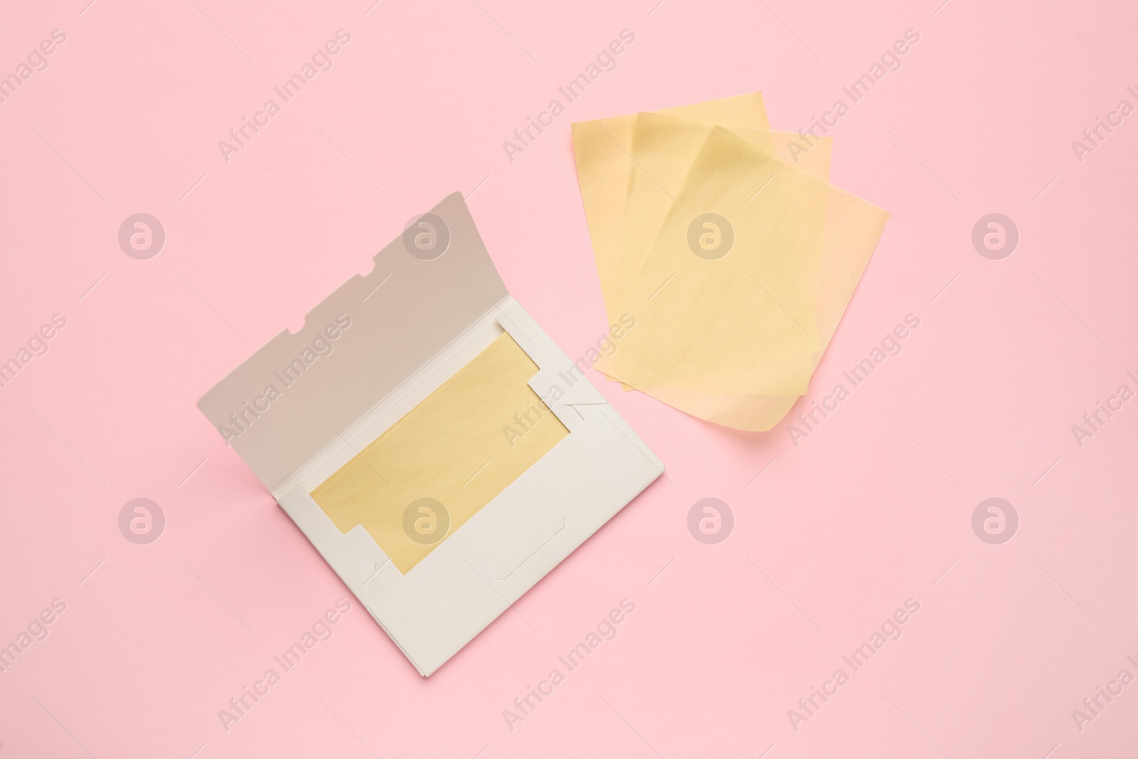 Photo of Facial oil blotting tissues on pink background, flat lay. Mattifying wipes