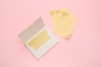 Photo of Facial oil blotting tissues on pink background, flat lay. Mattifying wipes