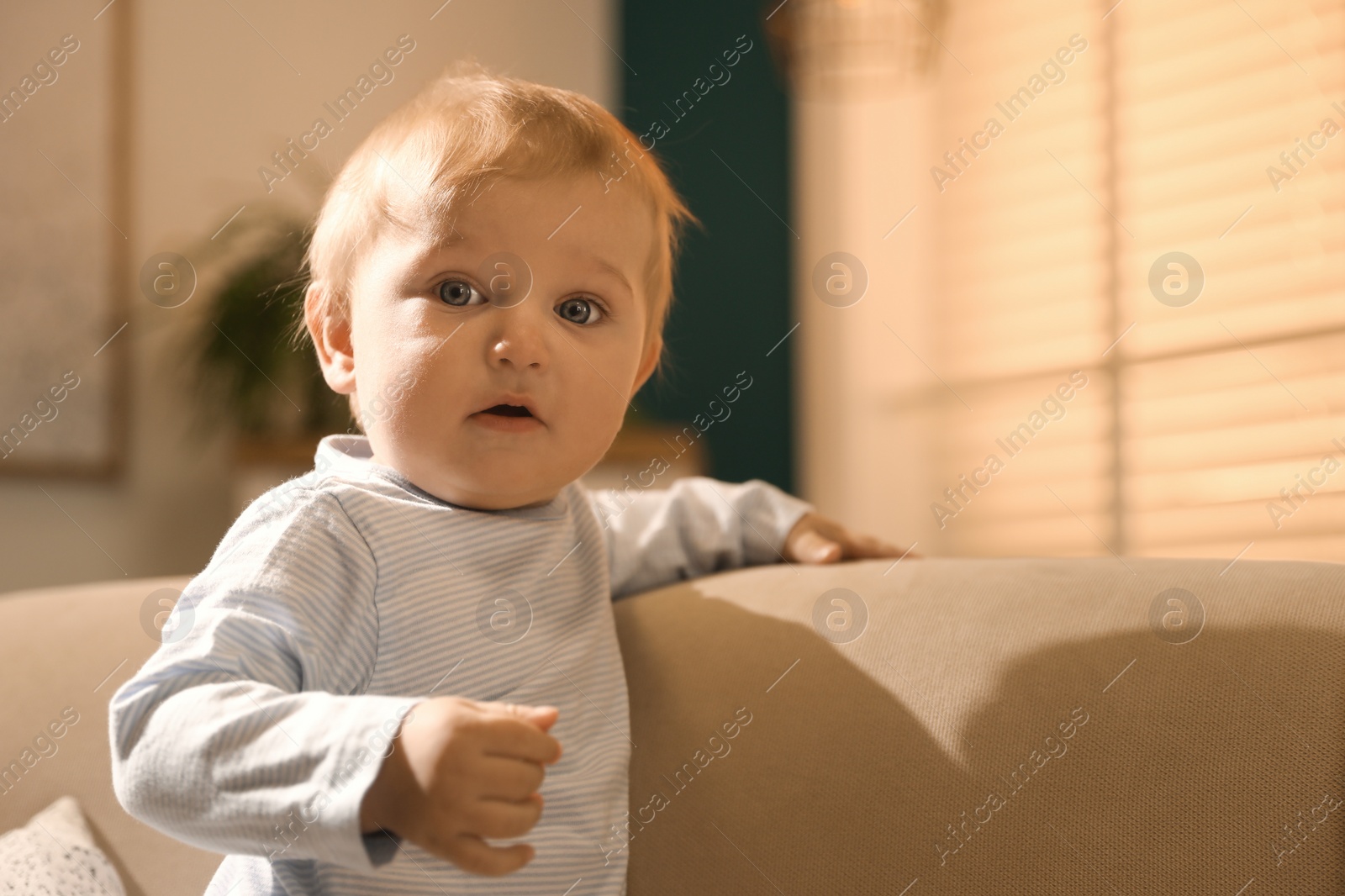 Photo of Cute little baby with on sofa indoors