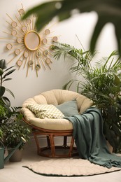 Photo of Lounge area interior with comfortable papasan chair and houseplants