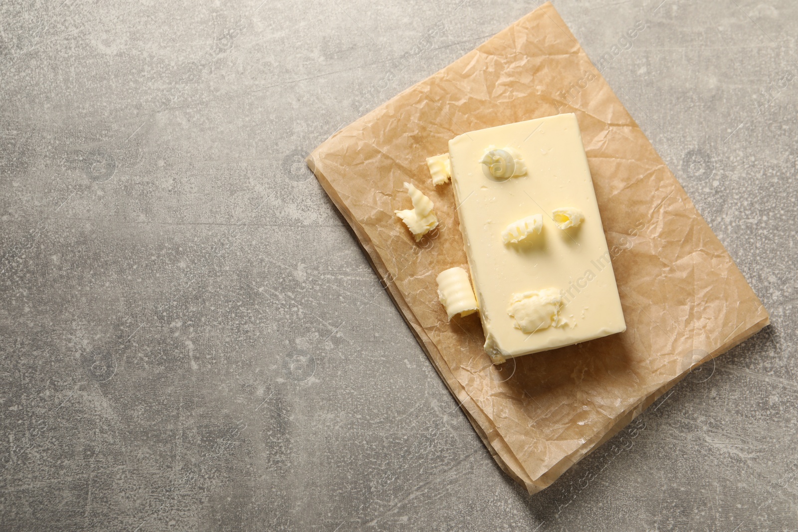 Photo of Tasty butter on grey table, top view. Space for text